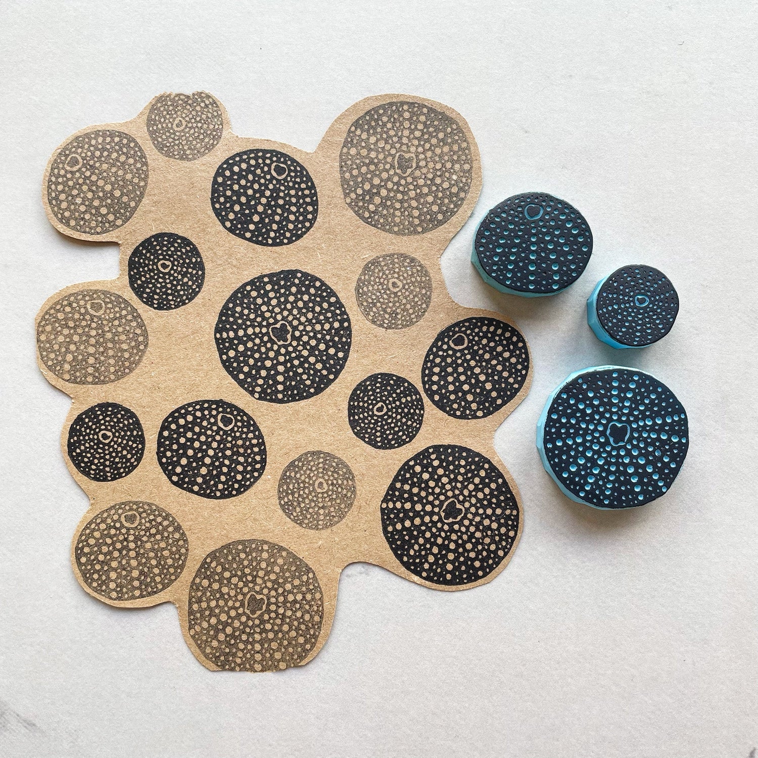 Hand carved sea urchin rubber stamps with stamped pattern on kraft paper