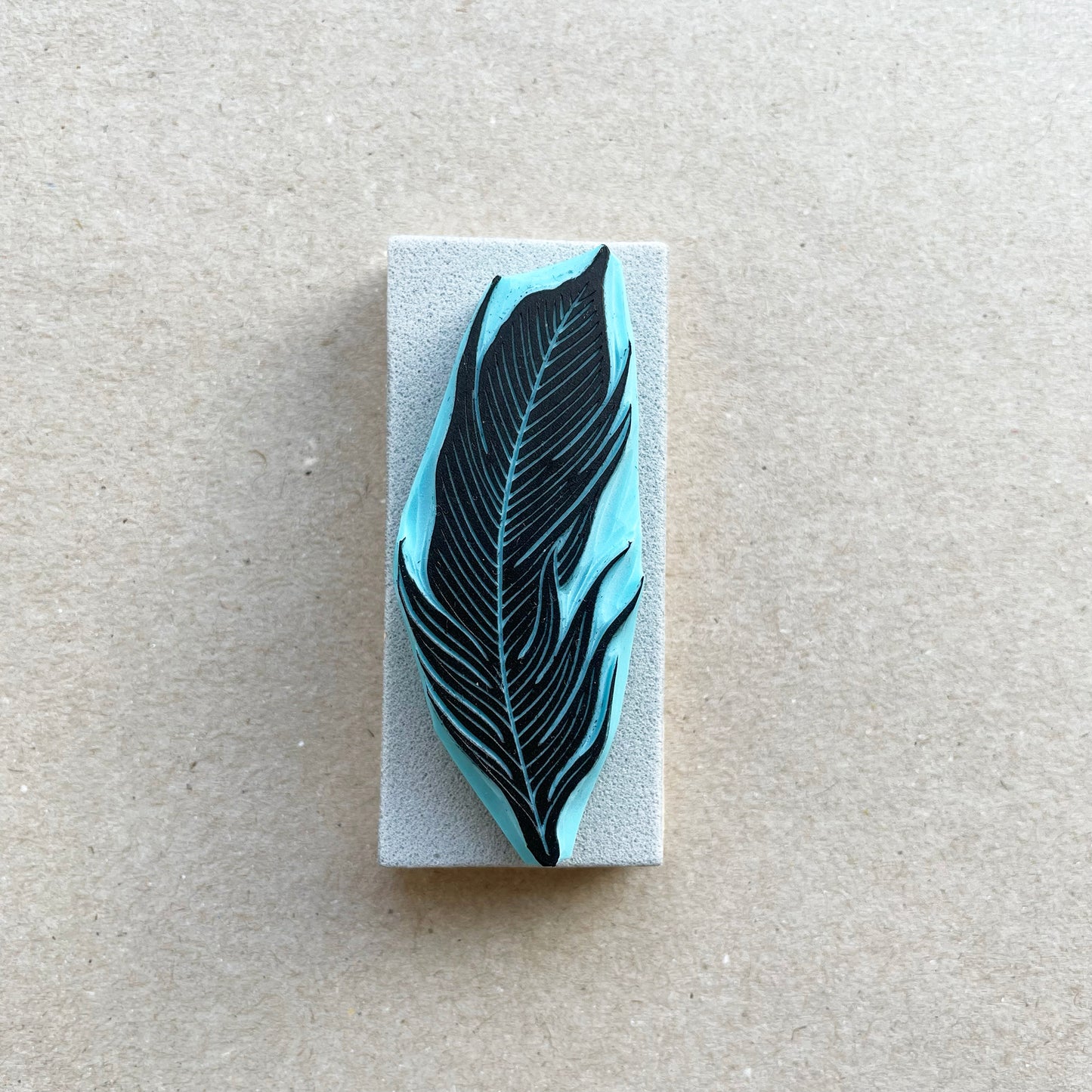 front view of a bird feather rubber stamp with wood base