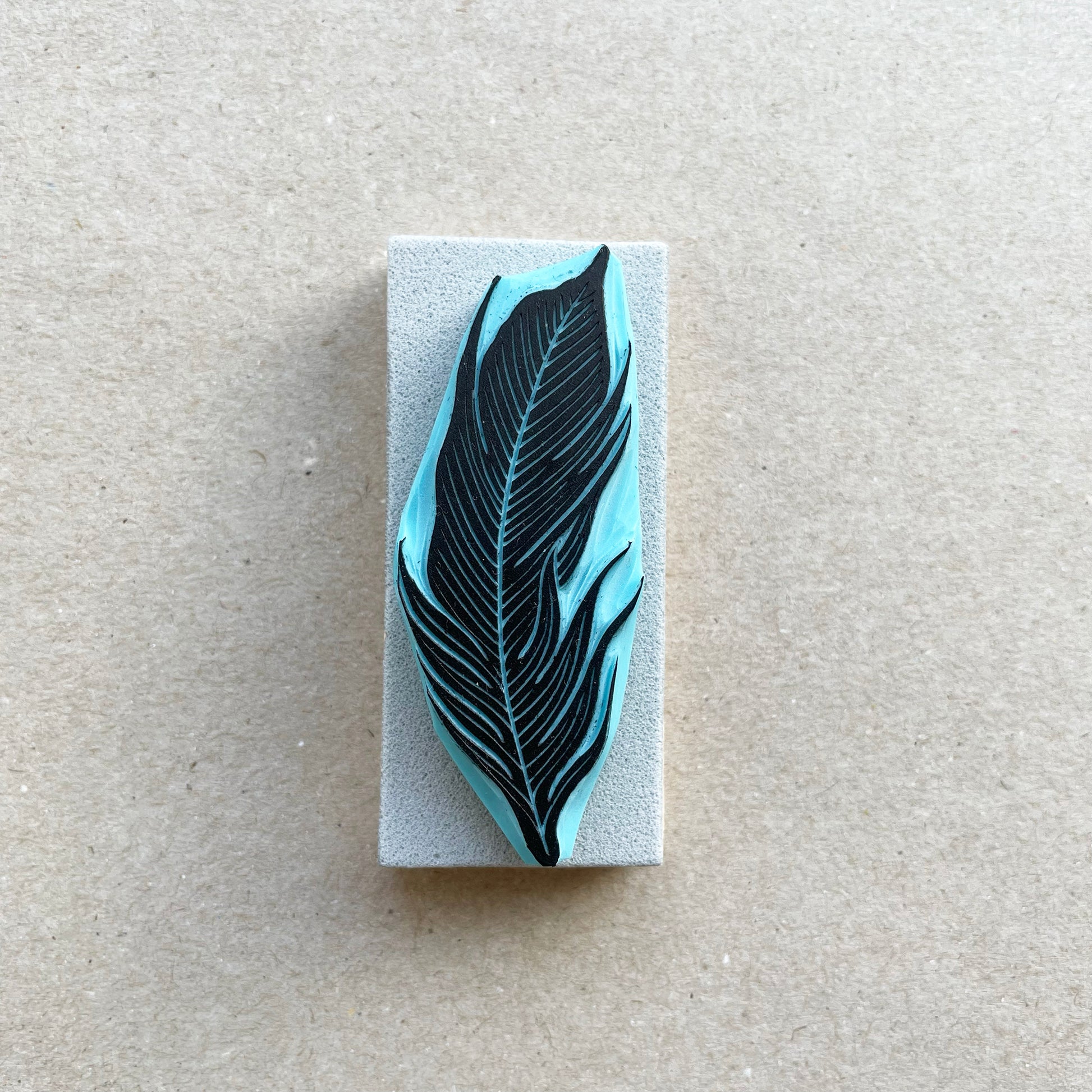 front view of a bird feather rubber stamp with wood base
