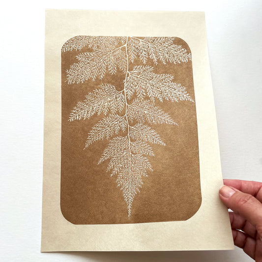 Block print of a fern in gold ink