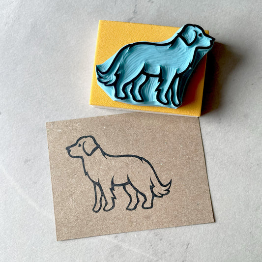Hand carved rubber stamp of the outline shape of a labrador dog. Image stamped on kraft paper.
