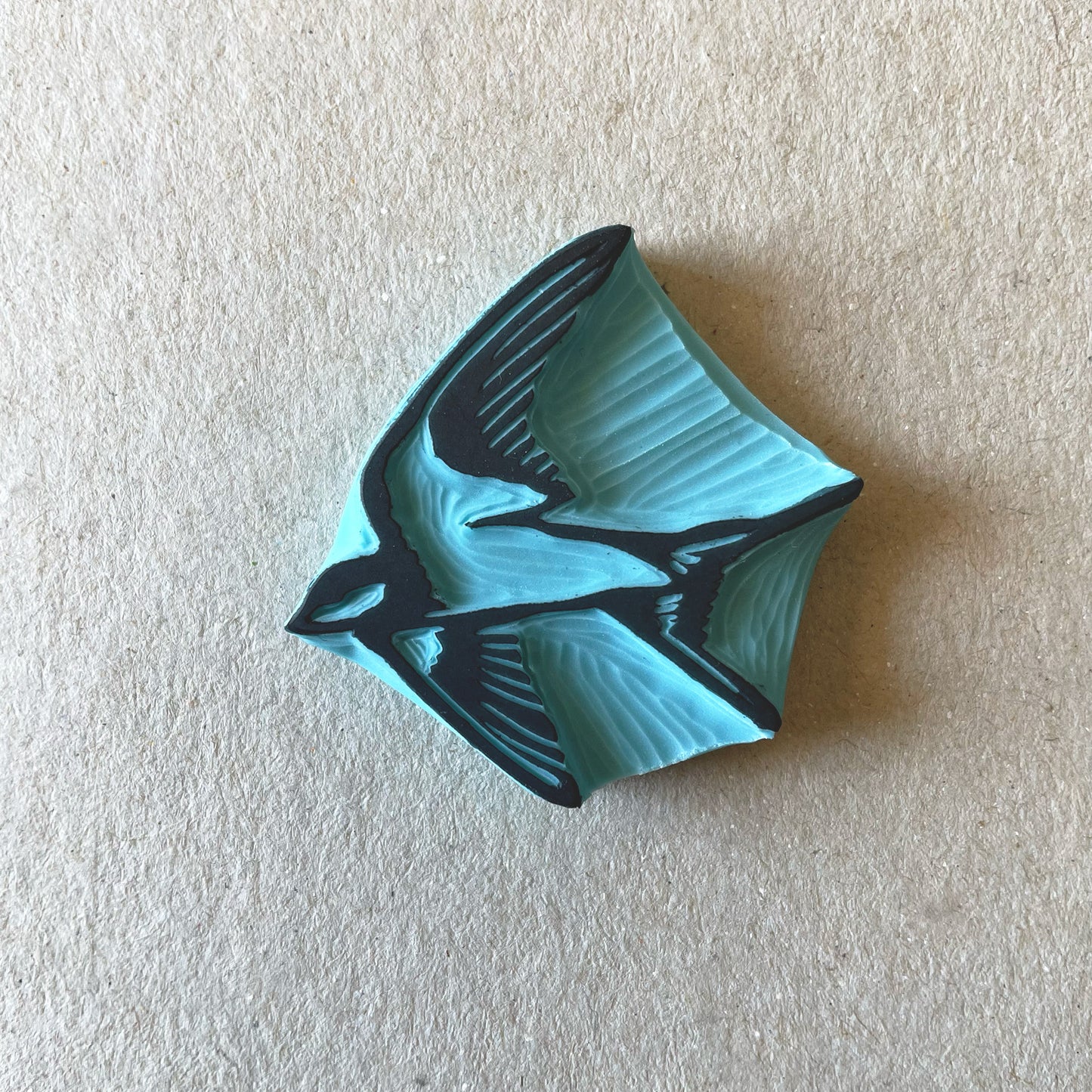 hand carved rubber stamp of a swallow bird on a grey background