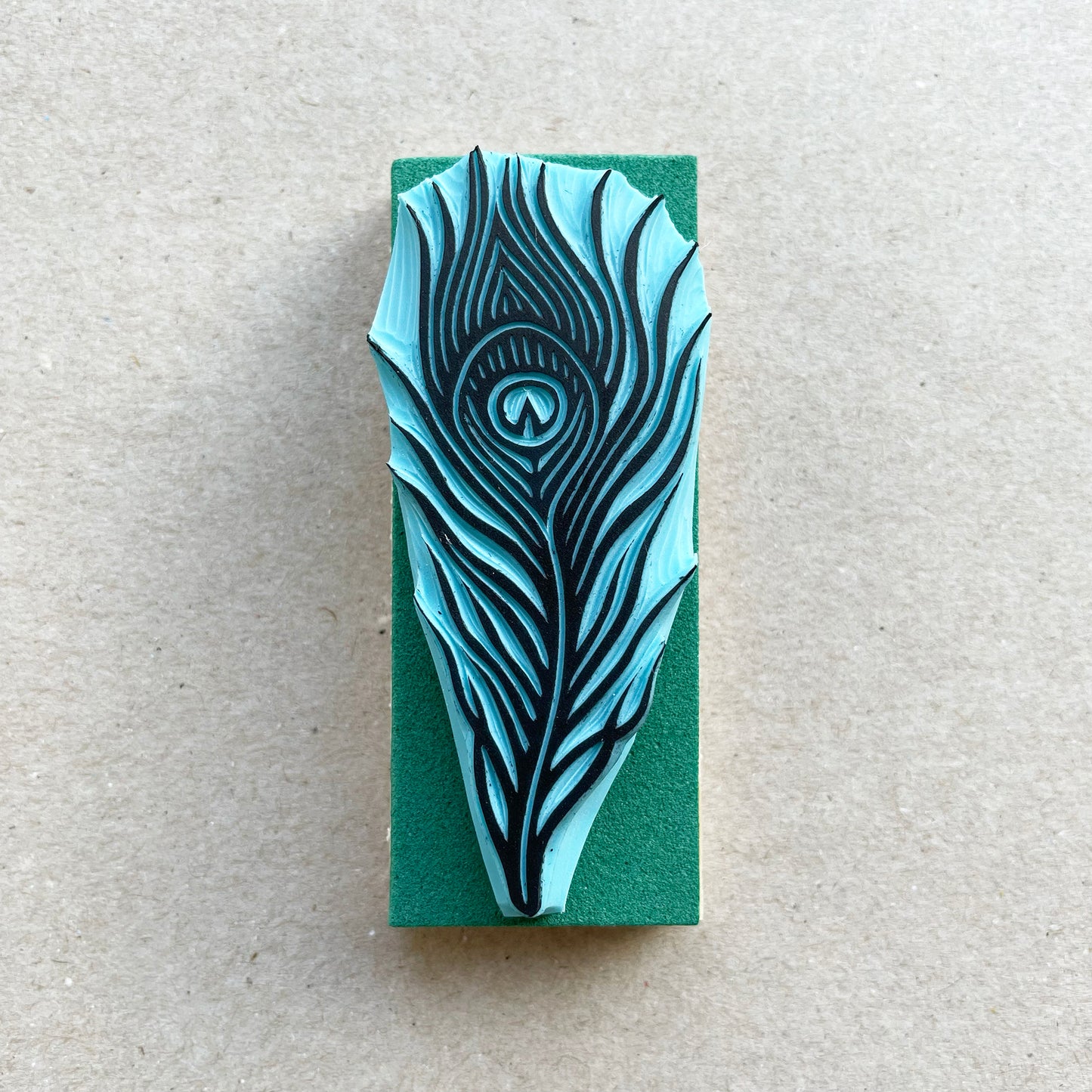 front view of a peacock bird feather rubber stamp with wood base
